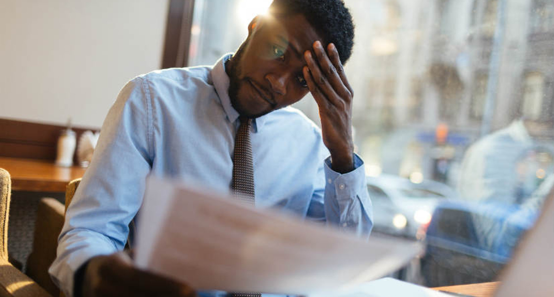 Man reviewing a UK immigration application at a cafe table